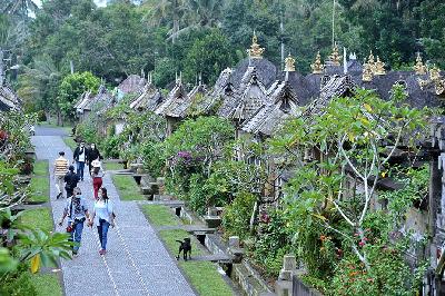 Wisatawan berjalan di sekitar deretan rumah tradisional di Desa Wisata Penglipuran, Bangli, Bali, 26 Februari 2021.  ANTARA/Fikri Yusuf