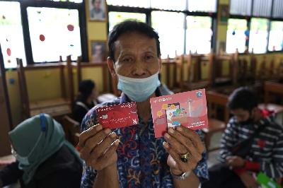 Warga menunjukkan buku tabungan dan atm Bank DKI saat penyaluran Bantuan Sosial Tunai di SDN 01 Rambutan, Jakarta, 13 Januari 2021. TEMPO/Muhammad Hidayat