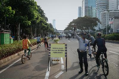 Petugas berjaga di dekat jalur khusus sepeda di Jalan Jenderal Sudirman, Jakarta, 14 Maret 2021. TEMPO/M Taufan Rengganis