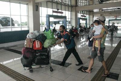 Petugas mendorong barang milik penumpang untuk dimasukan ke dalam bus sebelum melakukan keberangkatan Terminal Terpadu Pulo Gebang, Jakarta, 11 Februari 2021. TEMPO/Hilman Fathurrahman W