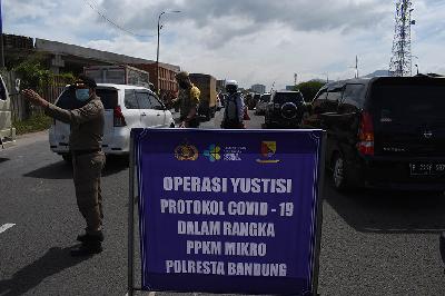 Petugas melaksanakan operasi Satgas Covid-19 di exit tol Cileunyi, Kabupaten Bandung, Jawa Barat, 11 Maret 2021. TEMPO/Prima Mulia