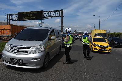 Petugas menghentikan kendaraan dari luar kota  yang terjaring operasi Satgas Covid-19 saat berkendara melewati exit tol Cileunyi, Kabupaten Bandung, Jawa Barat, 11 Maret 2021. TEMPO/Prima Mulia