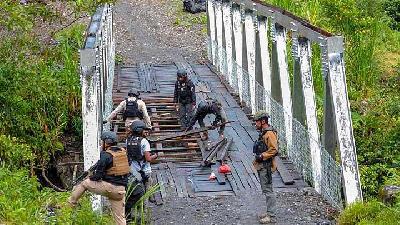 Anggota Brimob memperbaiki jembatan yang dirusak Kelompok Kriminal Bersenjata di Distrik Yambi, Kabupaten Puncak Jaya. Dok AKBP Edwin Louis Sengka