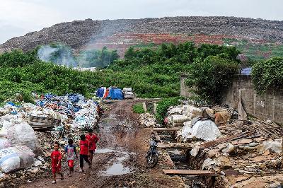 Anak-anak bermain dengan latar belakang gunung sampah di Tempat Pengolahan Sampah Terpadu (TPST) Bantar Gebang, Bekasi, Jawa Barat, 8 Januari 2021. TEMPO/Hilman Fathurrahman W