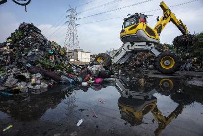 Pekerja dengan menggunakan alat berat memindahkan sampah di area proyek Fasilitas Pengolahan Sampah Terpadu atau "Intermediate Treatment Facility" (ITF) Sunter, Jakarta, 12 Februari 2019.  ANTARA/Aprillio Akbar