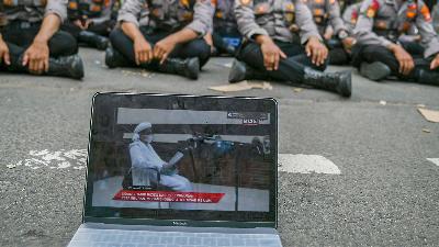 Video yang menampilkan suasana sidang secara langsung kasus pelanggaran protokol kesehatan dengan terdakwa Rizieq Syihab di halaman Pengadilan Negeri (PN) Jakarta Timur, Jakarta, Jumat (26/3/2021)./ANTARA FOTO/Galih Pradipta