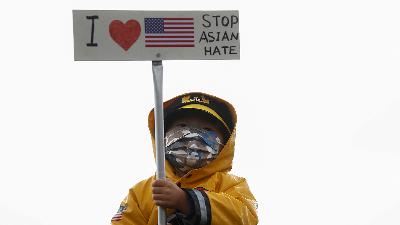 A child holds a sign with a US flag at a “Stop Asian Hate” rally and vigil to remember the Atlanta shooting victims at Bellevue Downtown Park in Bellevue, Washington, US, March 20.
Reuters/Lindsey Wasson
