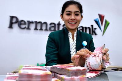 Petugas teller menghitung uang rupiah di Bank Permata, Jakarta. TEMPO/Tony Hartawan