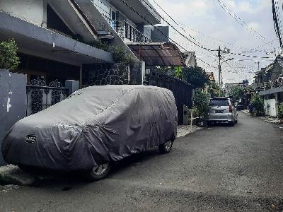 Kendaraan diparkir di tepi jalan di pemukiman warga Kampung Pulo, Jakarta, 29 Maret 2021. TEMPO/Hilman Fathurrahman W