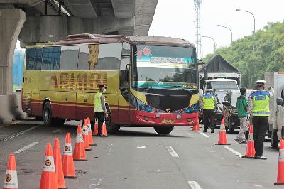 Polisi menghentikan bus yang mengangkut penumpang untuk mudik di tol Jakarta-Cikampek, Cikarang, Kabupaten Bekasi, Jawa Barat, 25 April 2020. TEMPO/Hilman Fathurrahman W