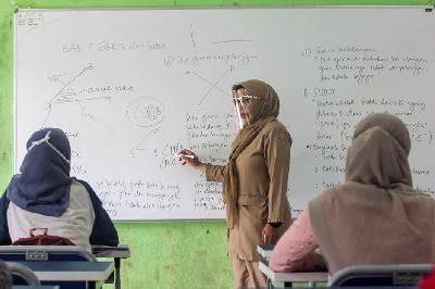 Seorang guru menjelaskan materi kepada siswa saat pembelajaran tatap muka di SMP Negeri 2 Bekasi, Kota Bekasi, Jawa Barat, 22 Maret 2021.  TEMPO / Hilman Fathurrahman W