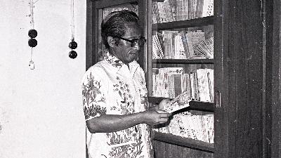 Kho Ping Hoo atau Asmaraman Sukowati membaca buku di rumahnya, di Solo, Jawa Tengah, 1977. Dok. TEMPO/Kastoyo Ramelan