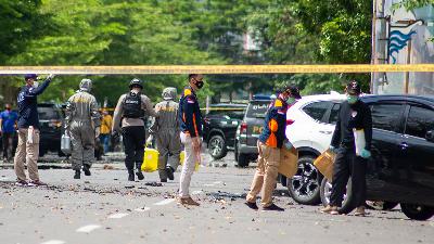 Petugas kepolisian melakukan pemeriksaan di sekitar sisa-sisa ledakan bom bunuh diri di depan Gereja Katedral, Makassar, Sulawesi Selatan, Minggu 28 Maret 2021./TEMPO/Iqbal Lubis