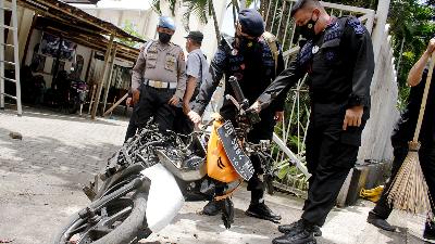 Police officers looking at a motorcycle used by the suicide bombers outside the Makassar Cathedral Church in South Sulawesi, March 29.
Antara/Arnas Padda

