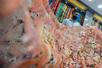 Pekerja merapikan kain yang dijual di Pasar, Baru, Jakarta, 5 April 2021. Tempo/Tony Hartawan