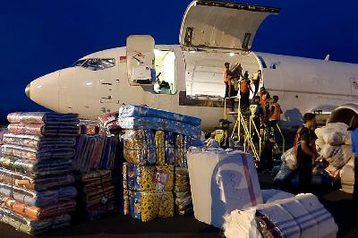 Pekerja membongkar muat bantuan logistik Kementerian Sosial untuk korban banjir dan tanah longsor di NTT, di Bandara Frans Seda, Maumere, NTT, 5 April 2021. ANTARA/Dedy