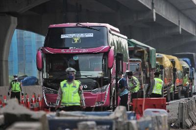 Polisi menindak bus berpenumpang saat penerapan pelarangan mudik 2020 di Akses Tol Jakarta Cikampek, Cikarang, Kabupaten Bekasi, Jawa Barat, 5 Mei 2020. TEMPO/Hilman Fathurrahman W