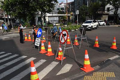 Petugas Dishub DKI Jakarta mengatur arus lalu lintas kendaraan saat uji coba penerapan sistem satu arah di kawasan Gondangdia, Jakarta Pusat, 8 April 2021. ANTARA/Indrianto Eko Suwarso