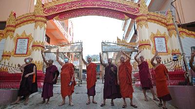 Para biksu Buddha menunjukkan salam tiga jari sebagai bentuk dukungan terhadap unjuk rasa memprotes kudeta militer di Yangon, Myanmar, 8 Februari 2021. REUTERS / Stringer 