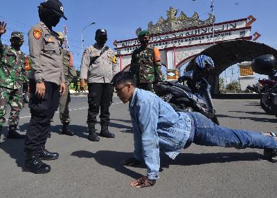 Petugas gabungan Satgas COVID-19 Kota Bandar Lampung memberikan hukuman kepada pengendara motor yang tidak mengenakan masker di Bandar Lampung, Lampung,15 April 2021. ANTARA/Ardiansyah