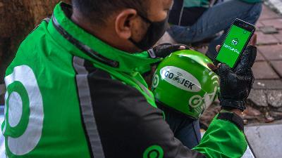 A Gojek driver opens the Tokopedia app during a break in Jakarta, April 23. The merger of the two startup unicorns is estimated to be worth US$40 billion or around Rp581 trillion.
Tempo/Tony Hartawan
