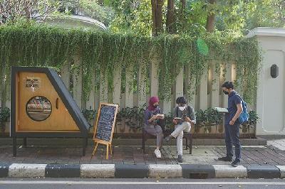 Warga membaca buku di dekat perpustakaan bersama Bookhive Jakarta di Taman Situ Lembang, Jakarta, 26 April 2021. TEMPO/Muhammad Hidayat