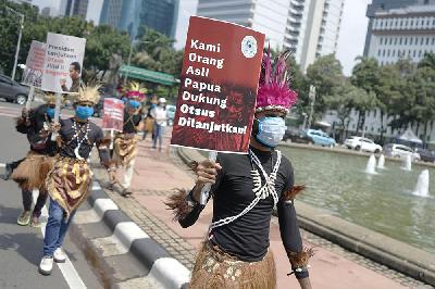 Sejumlah massa memakai pakaian adat melakukan aksi di Bundaran Patung Kuda, Jakarta, 1 Maret 2021. TEMPO/Muhammad Hidayat