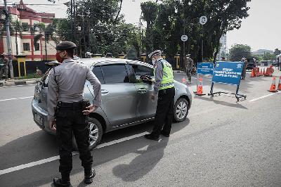 Petugas gabungan melakukan pengecekan Surat Izin Keluar Masuk (SIKM) Jakarta kepada pengendara dengan mobil bernomor polisi luar Jabodetabek di Pos Pemantauan PSBB Pasar Jumat, Jakarta, 26 Mei 2020. TEMPO/M Taufan Rengganis