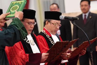 Hakim Konstitusi Aswanto (kiri) dan Wahiduddin Adams mengucapkan sumpah di hadapan Presiden Joko Widodo di Istana Negara, Jakarta, 2019. Antara/Wahyu Putro A