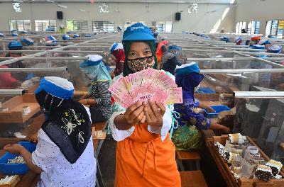 Pekerja menunjukkan uang Tunjangan Hari Raya (THR) yang diterimanya di sebuah di Kudus, Jawa Tengah, 29 April 2021.  ANTARA/Yusuf Nugroho