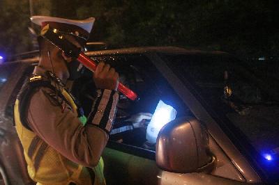 Petugas kepolisian memeriksa dokumen pengendara yang melintas dari arah Jakarta menuju Cikampek di Pintu Tol keluar Cikarang Barat, 6 Mei 2021 dini hari. TEMPO/Hilman Fathurrahman W