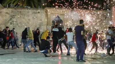Warga Palestina bereaksi ketika polisi Israel menembakkan granat selama bentrokan di kompleks Masjid Al-Aqsa,di Kota Tua Yerusalem, 7 Mei 2021. REUTERS / Ammar Awad