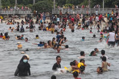 Wisatawan berenang pada hari ke-dua Lebaran di Pantai Ancol, Jakarta, 14 Mei 2021. TEMPO/Hilman Fathurrahman W