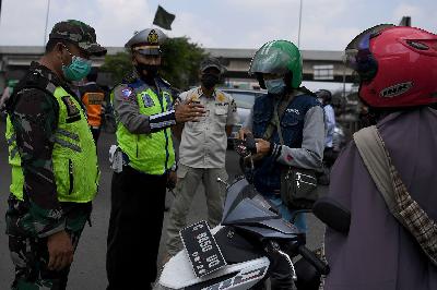 Petugas gabungan memberhentikan pengendara motor di pos penyekatan mudik Sumber Artha, Bekasi, Jawa Barat, 14 Mei 2021. ANTARA/Sigid Kurniawan