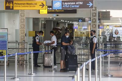 Petugas keamanan memeriksa dokumen perjalanan seorang penumpang di  Bandara I Gusti Ngurah Rai, Kuta, Bali, 10 Mei 2021. TEMPO/Johannes P. Christo