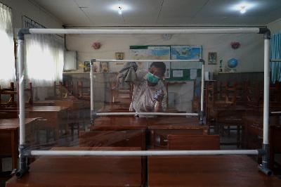 Petugas mempersiapkan ruangan kelas untuk Penerimaan Peserta Didik Baru (PPDB) di SMP Negeri 115 Jakarta, Tebet, Jakarta, 21 Mei 2021. TEMPO/Muhammad Hidayat