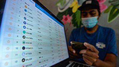 A crypto investor is pictured monitoring the movement of Bitcoin on his computer screen and mobile phone at a café in Jakarta, May 20. The Indonesian Blockchain Association (ABI) revealed that, according to Indodax’s record, there are currently 1.7 million bitcoin players in Indonesia.
Tempo/Tony Hartawan
