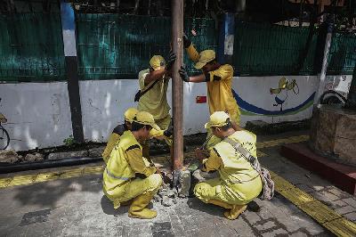 Petugas Satuan Bina Marga Jakarta Selatan mencabut tiang listrik yang tak terpakai di Jakarta. Tempo/M. Taufan Rengganis