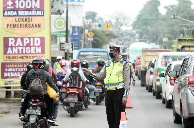 Petugas mengatur lalu lintas dekat Pos Penyekatan Raya Parung Ciputat saat arus balik mudik di Depok, Jawa Barat, 18 Mei 2021. TEMPO/Nurdiansah