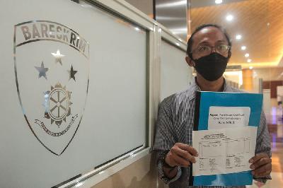 Peneliti Indonesia Corruption Watch (ICW) Wana Alamsyah menunjukkan barang bukti saat melaporkan Ketua KPK Filri Bahuri atas dugaan penerimaan gratifikasi di Bareskrim Polri, Jakarta, 3 Juni 2021. TEMPO/Hilman Fathurrahman W