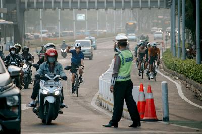 Anggota Polisi mengarahkan pesepeda road bike yang berada diluar jalur sepeda agar kembali ke jalur khusus di kawasan Bundaran Senayan, Jakarta, 2 Juni 2021. TEMPO/M Taufan Rengganis