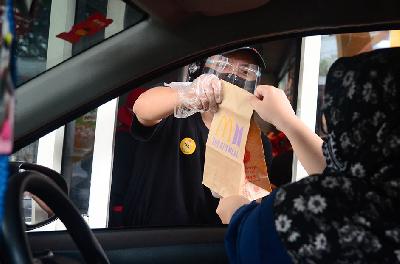 Karyawan tengah memberikan pesanan BTS Meal kepada pembeli secara drive thru di gerai McDonald's Bintaro, Tangerang Selatan, Banten, 9 Juni 2021. Tempo/Nurdiansah