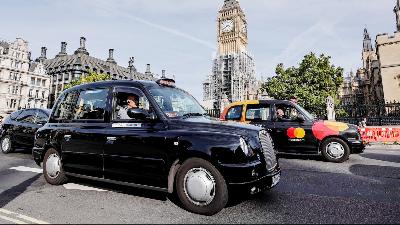 Pengemudi taksi uber dan taksi konvensional London, saat melintasi Gedung Parlemen Inggris, di London, September 2017. REUTERS/Eddie Keogh
