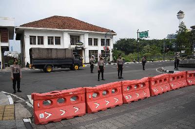Polisi berjaga di simpang Jalan Asia Afrika dan Jalan Ir Sukarno, Bandung, Jawa Barat, yang ditutup untuk lalu lintas kendaraan atau aktivitas masyarakat, 18 Juni 2021. TEMPO/Prima Mulia