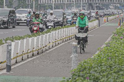 Pesepeda melintasi jalur sepeda permanen di kawasan Jalan Jendral Sudirman , Jakarta, 17 Juni 2021. TEMPO/Muhammad Hidayat