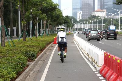 Pesepeda melintasi jalur khusus sepeda yang telah diberikan pembatas jalur permanen di Jalan Jenderal Sudirman, Jakarta, 26 Februari 2021. TEMPO/Muhammad Hidayat