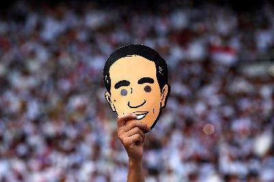 Pendukung memegang topeng kartun berwajah Presiden Joko Widodo saat kampanye Pemilihan Presiden 2019 di stadion Gelora Bung Karno, Jakarta, 13 April 2019. REUTERS/Willy Kurniawan