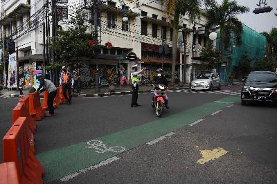 Petugas dibantu warga menutup akses masuk Jalan Asia Afrika untuk meredam mobilitas warga di Bandung, Jawa Barat, 18 Juni 2021. TEMPO/Prima Mulia