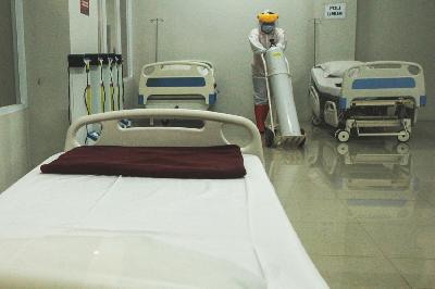Petugas mendorong tabung oksigen saat menyiapkan ruang isolasi bagi pasien yang terkonfirmasi positif Covid-19 di Tower 8 Rumah Sakit Darurat COVID-19 (RSDC) Pademangan, Jakarta, 15 Juni 2021. TEMPO/Hilman Fathurrahman W