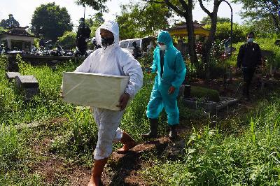 Petugas membawa jenazah bayi yang terkonfirmasi positif Covid-19 di pemakaman khusus Covid-19 TPU Cikadut, Bandung, Jawa Barat, 22 Juni 2021. TEMPO/Prima Mulia